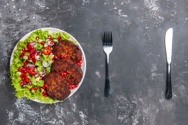 美味顶视图美味肉排与新鲜沙拉在灰色地板上的照片肉菜食品器具特纳沙拉