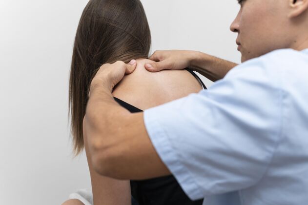 愈合理疗师按摩女病人的上背部女性背部治疗