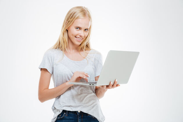 大学一个微笑的女人使用笔记本电脑 看着隔离在白色背景上的相机的肖像站电脑在线