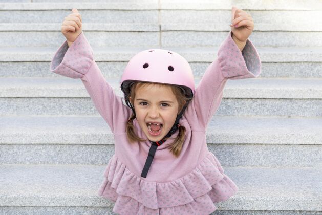 年轻画一个戴头盔的小女孩举起双手头盔快乐女孩