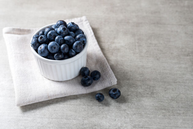 素食很多新鲜美味的蓝莓放在木桌上的白色罐子里生的碗浆果