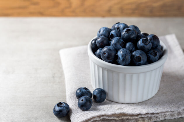 锅很多新鲜美味的蓝莓放在木桌上的白色罐子里浆果抗氧化剂陶瓷