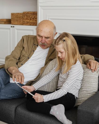 中镜头中枪祖父和女孩与平板电脑老人退休祖父母