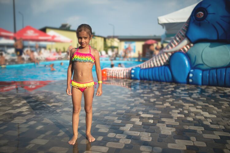 水小苗条可爱的女孩在明亮的游泳衣构成的儿童水域在一个温暖的露天背景夏季游泳池阳光