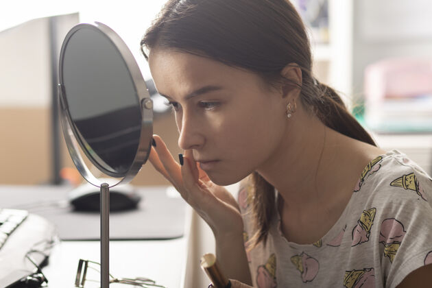 休闲少女在家对着镜子化妆青少年青少年肖像