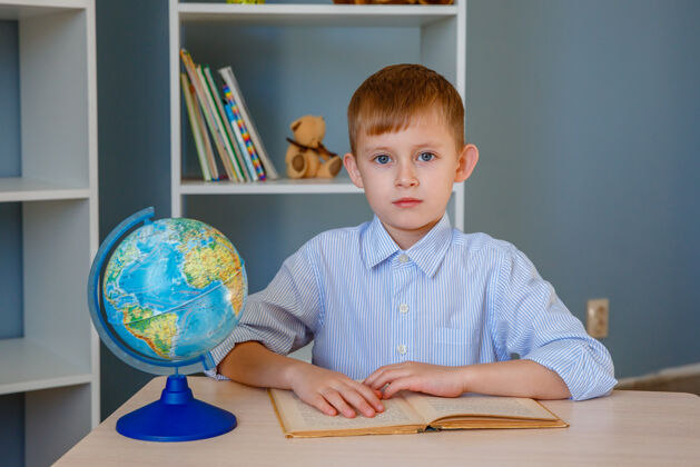 地球仪小男孩在桌边看书读书男孩小学生