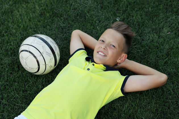 游戏帅哥足球运动员带着球躺在足球场上球运动幼儿园