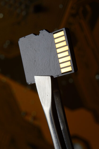 Pc在微电路的背景下 用镊子夹住微型sd存储卡的特写镜头安全商店技术