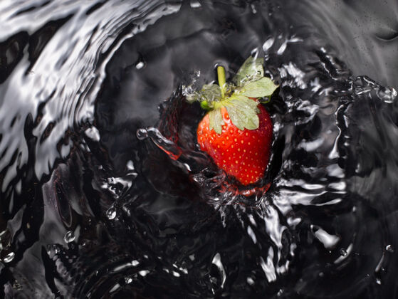 整体黑色背景下的一个草莓进水了成熟甜健康