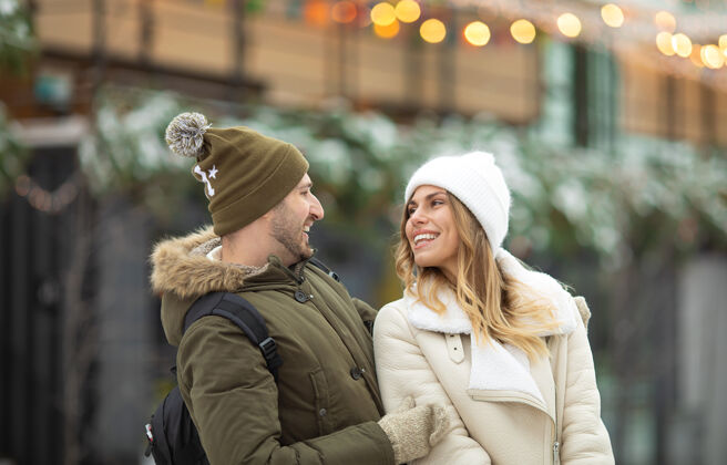 情侣在冬季公园里 拥抱着微笑着看着相机的情侣下雪情人户外