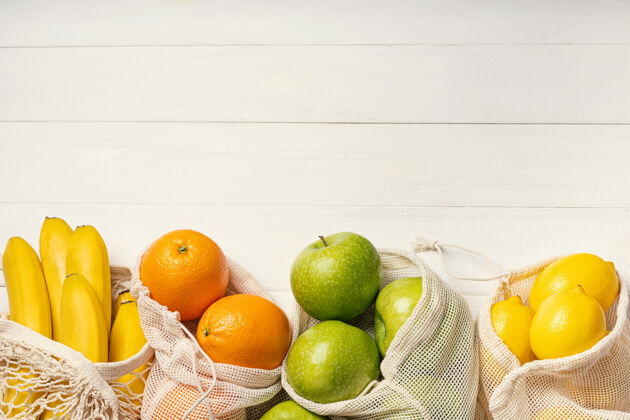 生的新鲜水果 苹果 香蕉 橘子和柠檬在环保袋零废物新鲜有机