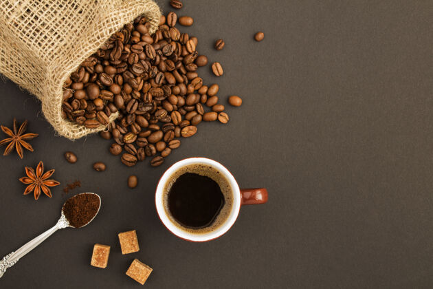 特写咖啡杯中的黑咖啡和深色背景上的咖啡豆的俯视图壁板袋子文本复制空间