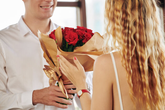 礼服男人送红玫瑰给女朋友的特写镜头新郎情侣礼物