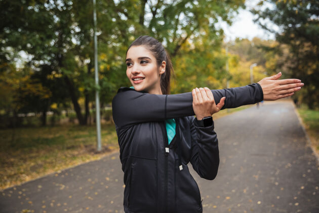 吸引力微笑的年轻健身女孩在公园锻炼身体年轻运动目标