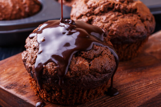 早午餐巧克力松饼和巧克力糖浆在黑暗中产品准备纸杯蛋糕