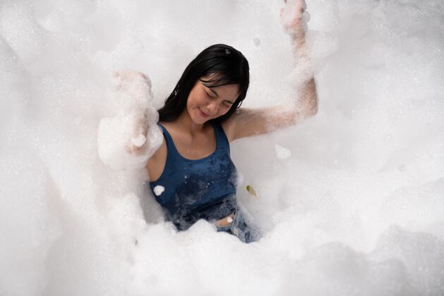 肥皂在泡泡池里玩得又开心又开心的女孩游戏泡沫快乐