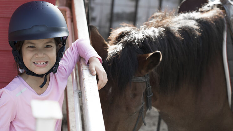 马术亚洲学童女孩骑马 在牧场骑马或练习骑马种马友谊女人