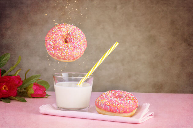 洞粉红色的甜甜圈和一杯牛奶在粉红色的表面茶松饼小