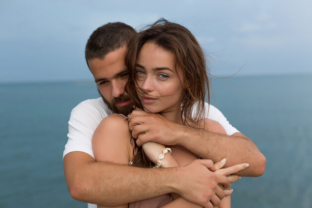 两个一对非常幸福的夫妇的肖像 他们在蓝色的海面上互相拥抱年轻快乐白种人