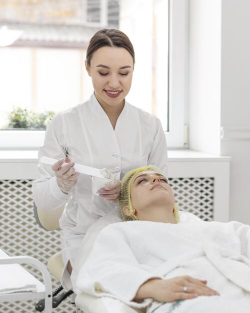 女性在美容诊所做面部护理的女人美容院客户面部护理