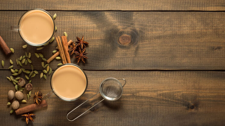 印度两个马萨拉茶杯放在一张木桌上香料.上衣查看桌子木头豆蔻