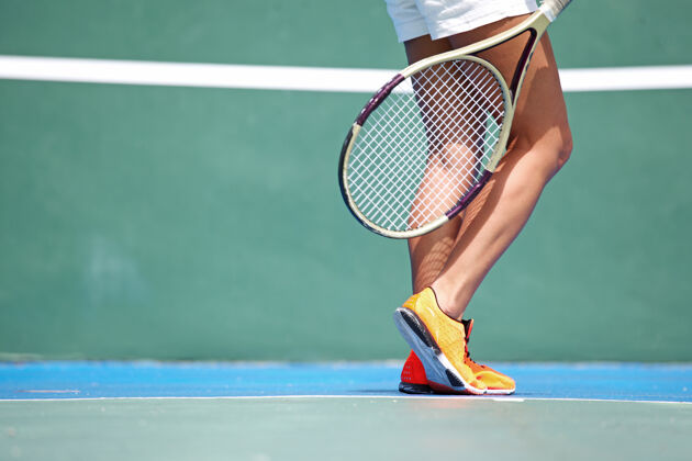 球女子网球运动员的腿在球场上游戏漂亮女人