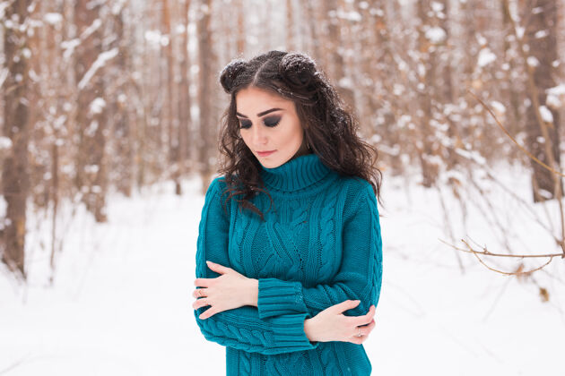 女性在阳光明媚的日子里 年轻漂亮的女人在冬天的雪地公园里散步明亮时尚户外