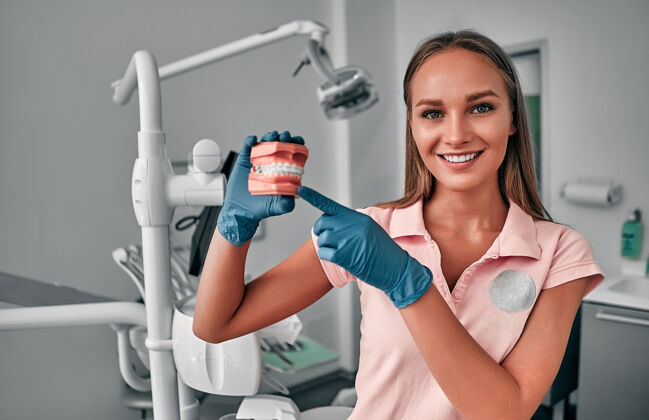 牙齿女牙医 在牙科诊所拿着一个下颌牙齿样本 接受正确的牙齿清洁培训 演示口腔卫生牙科医院工作