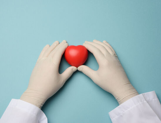 形状两只手戴着蓝色乳胶手套捧着一颗红心 捐赠理念 特写慈善符号医生