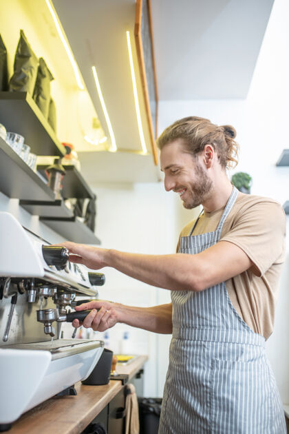围裙工作时刻年轻一个穿着围裙的帅哥在咖啡机旁忙碌着 心情很好成功男人清洗