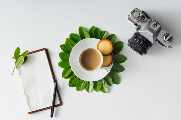 饮料创意平铺早晨咖啡花形笔记本和相机花早晨花园