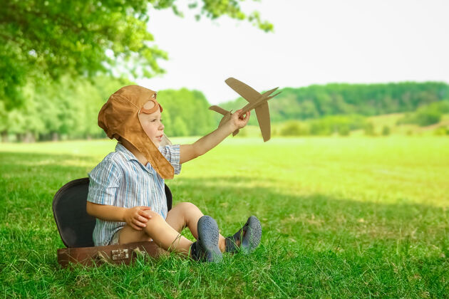 葡萄酒飞机旁的一个男婴在空中玩弄大自然公园男孩度假飞行员飞行员游戏户外