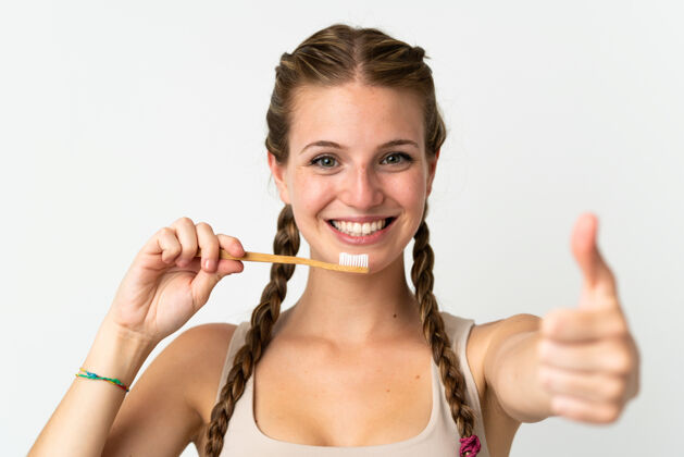 卫生一个年轻的白人妇女 拿着牙刷 被隔离在白色背景下牙刷早晨女人