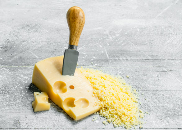 部分磨碎的奶酪刀开一张朴素的桌子产品意大利菜烹饪