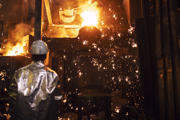 工作在铸造厂熔化铁和工人控制过程铸铁和生产 冶金和重工业车间安全重