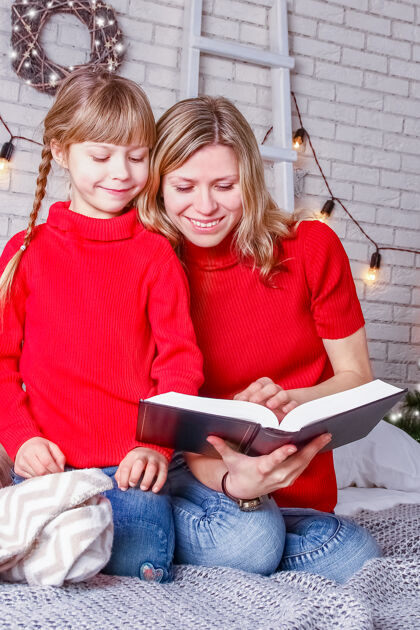 书圣诞快乐妈妈和孩子们在家看书庆祝年室内