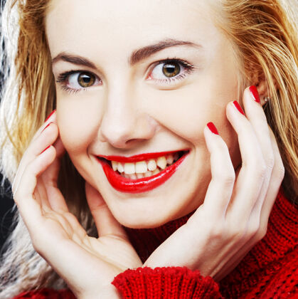 牙齿身着红色毛衣的迷人微笑金发女郎的肖像化妆品表达优雅
