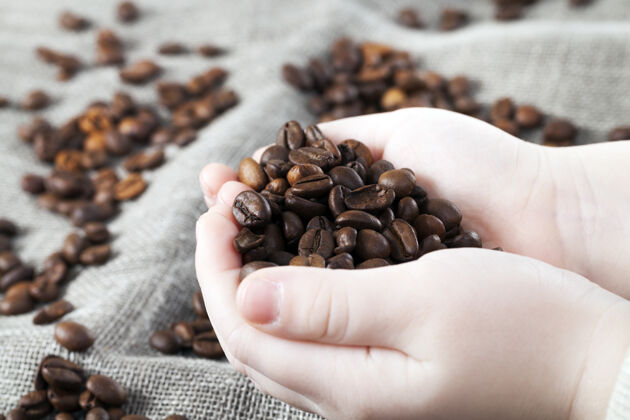 心脏芳香的咖啡粒躺在灰色的亚麻上谷物豆类早晨