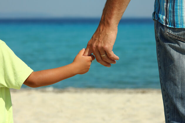 女儿夏天 父母在沙滩上牵着孩子的手小女性关怀