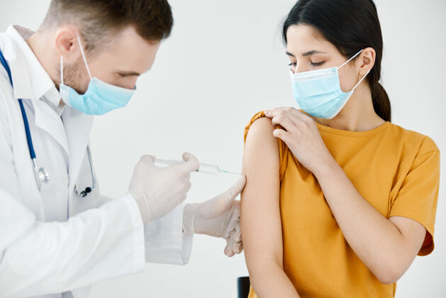 成人医生在医用口罩里给一个女人注射疫苗 肩部注射健康高加索种族健康仅成人