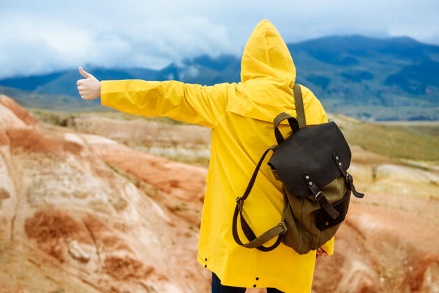 女人秋雨里背着背包在山上远足的女人人旅行者自然