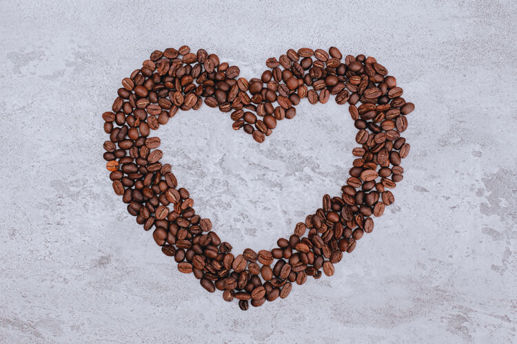 快乐心形咖啡豆与复制空间在中间谷物欢呼美丽