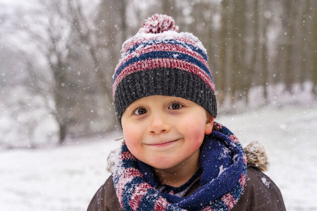 小小男孩戴着暖和的帽子和围巾在公园里的肖像冬天快乐幼儿喜欢雪和霜冻的天气孩子微笑冬天