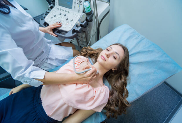 诊断医生用超声波扫描仪检查了一位妇女的甲状腺诊断测试设备