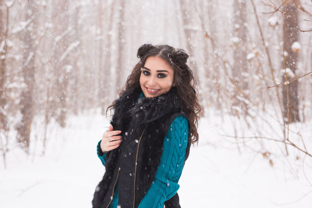 微笑在阳光明媚的日子里 年轻漂亮的女人在冬天的雪地公园里散步冷冻女孩模型