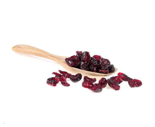 食物干蔓越莓放在木勺上隔离在白色水果宏堆