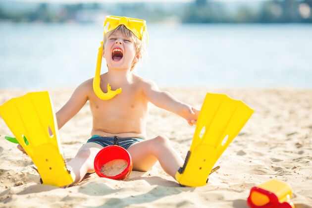 沙滩床上可爱的小男孩海滩孩子玩得开心吗海岸线可爱孩子们在水边玩得很开心海岸有乐趣可爱