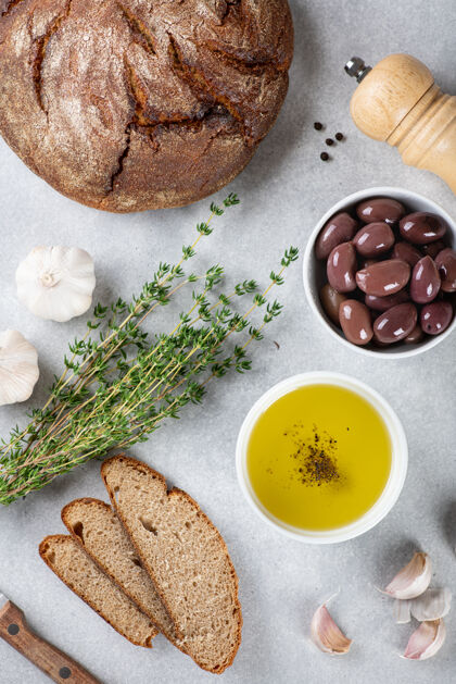 烹饪面包 橄榄油 卡拉马塔橄榄 大蒜和草药的蓝色背景 从上面看橄榄油维生素百里香