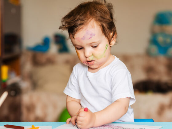 孩子快乐的小男孩用彩色铅笔在彩绘本上画画房子学校教育