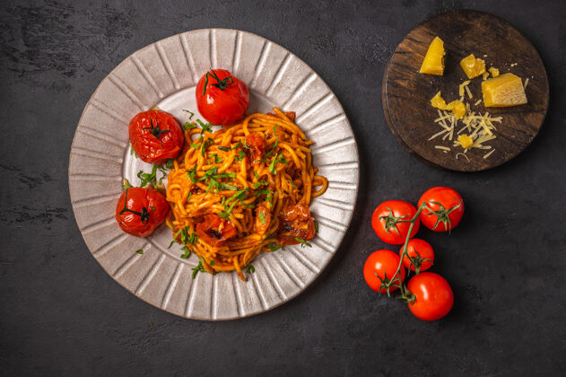 意大利意大利面配烤樱桃番茄 帕尔玛干酪和蒜酱 背景为深石墨色 俯视图 复印空间有机开胃菜健康